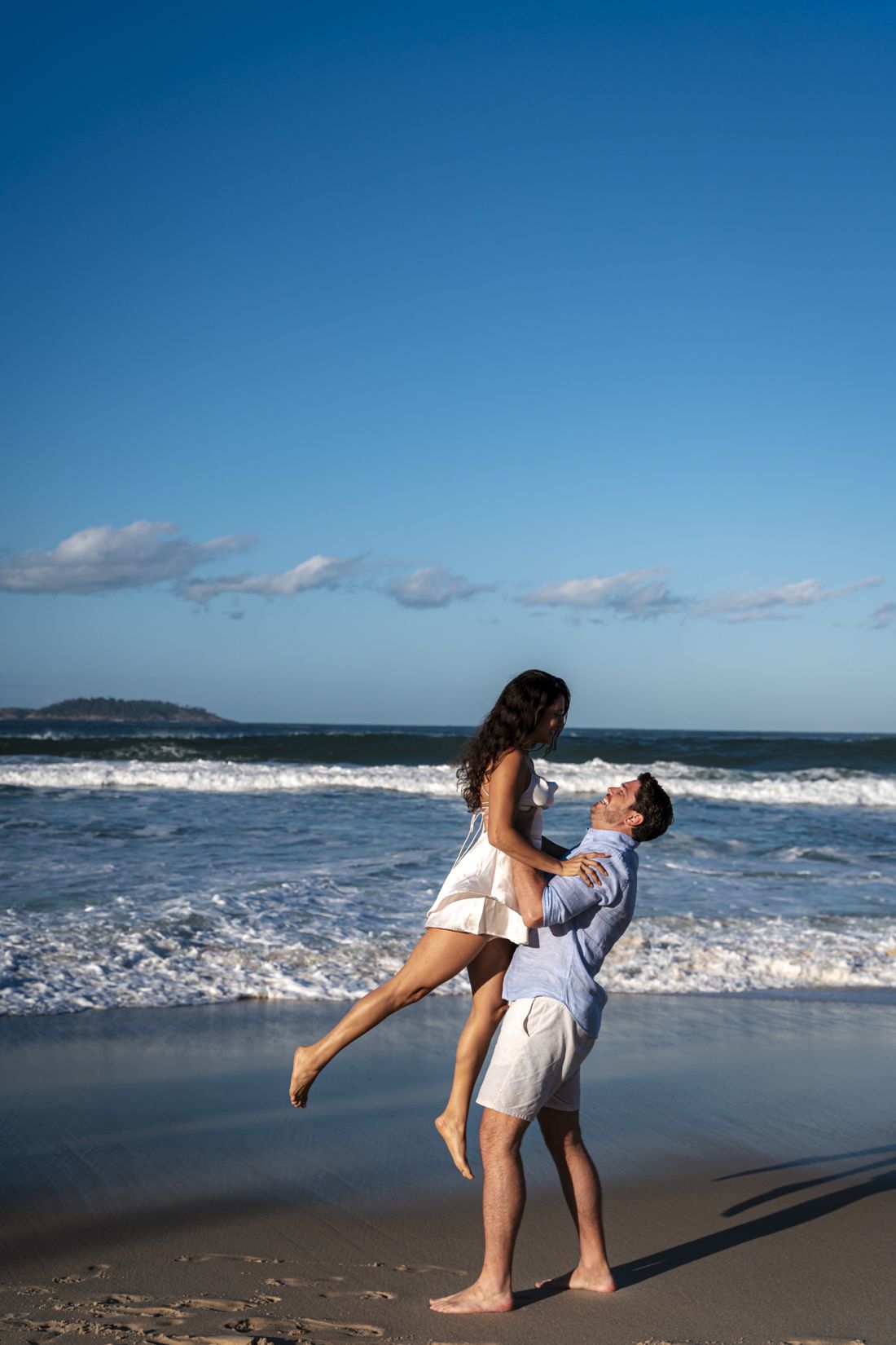 Jason levantando Mayra na beira do mar